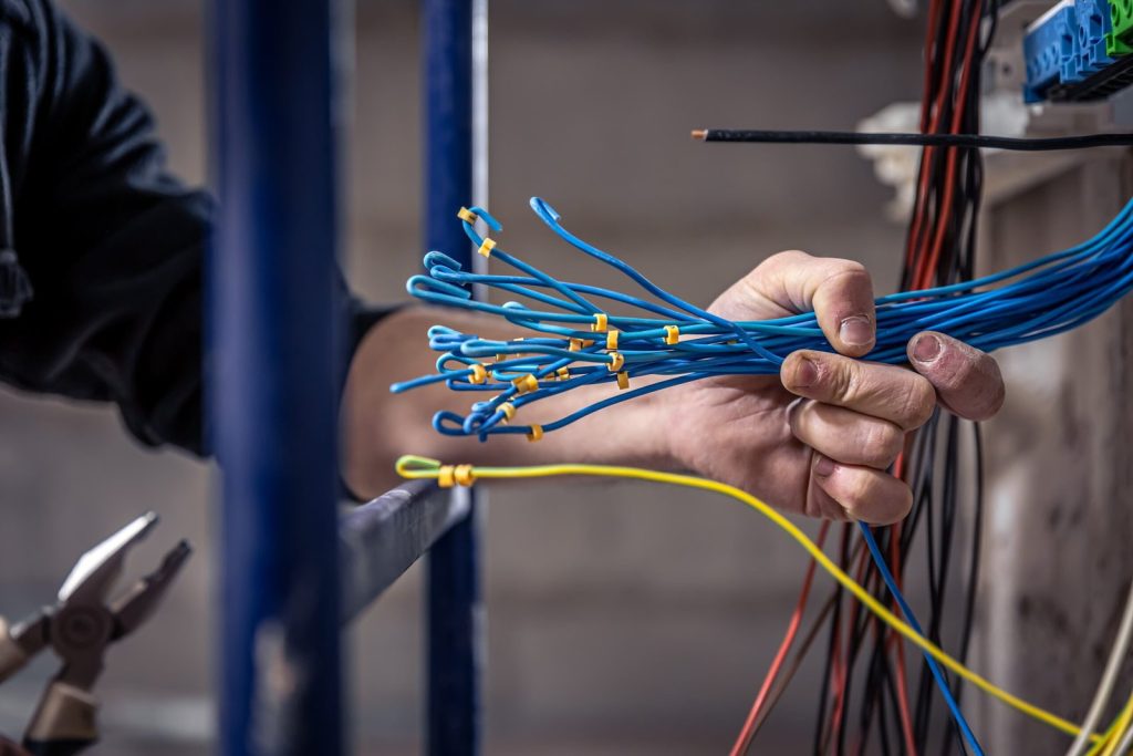male-electrician-works-switchboard-with-electrical-connecting-cable (1)